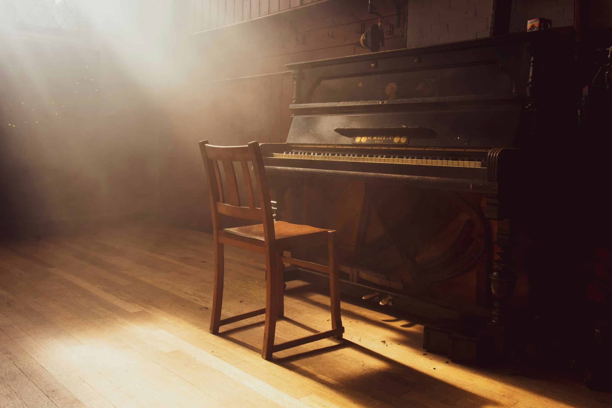 Piano on a spotlight stage — representing Elton John's music
